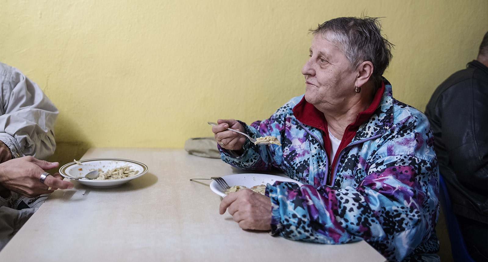 obdachlose Frau isst warme Mahlzeit